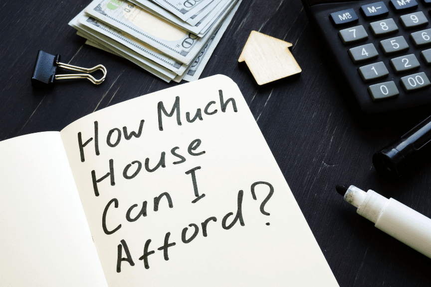 "How much house can I afford?" written on notepad next to house key and calculator representing modular home affordability.